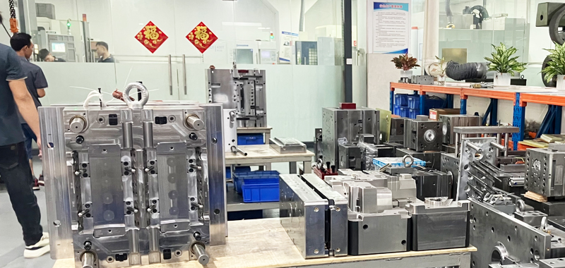 Remote factory audit via live video call showing mold production floor and quality inspection area